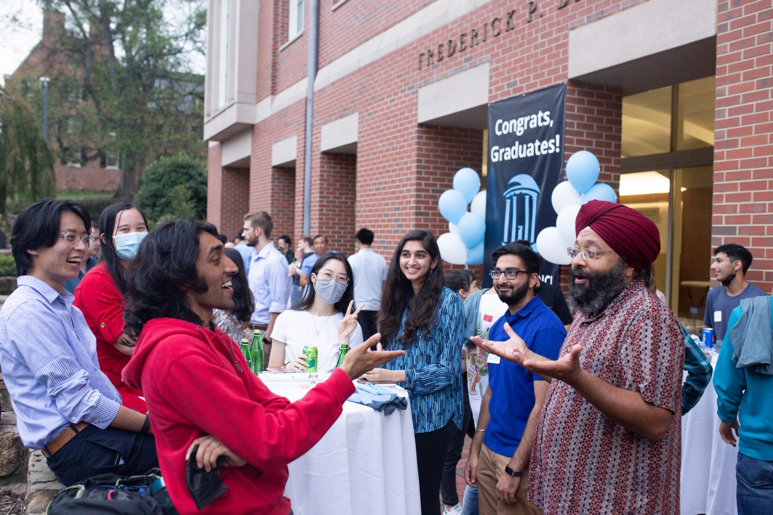 graduates and current students meet with Professor Montek Singh at the Class of 2020 Celebration