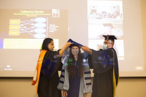 Catherine Nemitz is hooded by Professors Jasleen Kaur and Ketan Mayer-Patel during a ceremony in Sitterson Hall