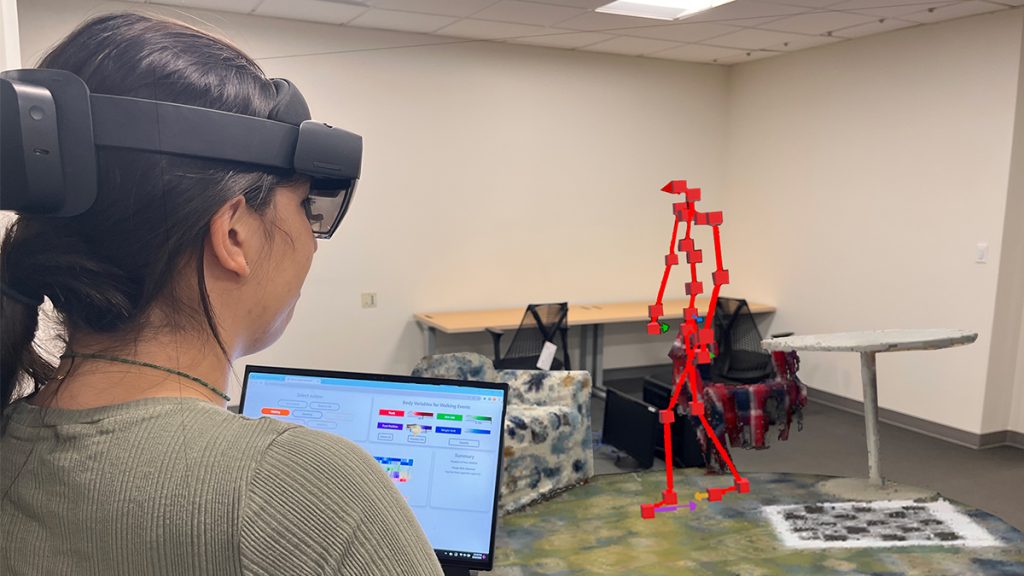 Doctoral student Jade Kandel observes an augmented reality visualization of a Parkinson's patient (simulated in the environment for illustrative purposes)
